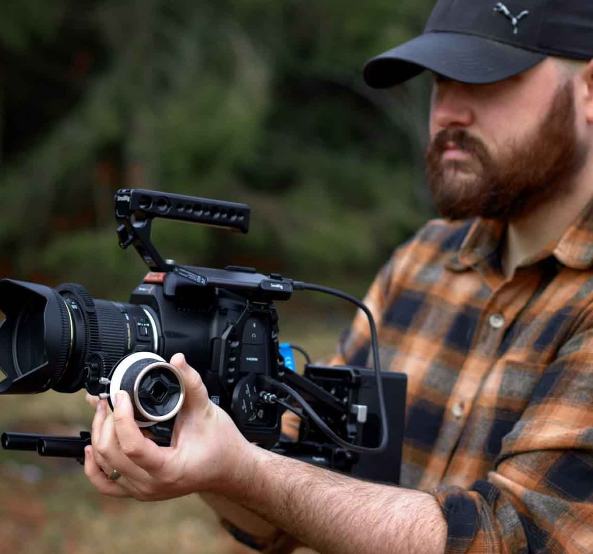 Nate Noye filming with the Black Magic Pocket Cinema 6K PRO with a Sigma 17 to 55 mm f2.8 lens in a smallrig brand camera cage.